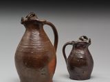 deux vases bruns posés l'un à côté de l'autre sur une surface blanche