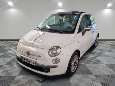 une petite voiture blanche garée sur un sol en damier