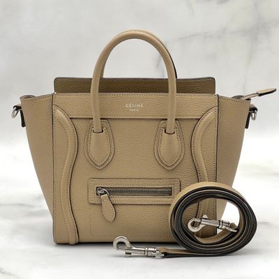 the small beige handbag is next to a leash on a marble surface