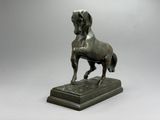 statue en bronze représentant un cheval sur un socle, sur fond gris