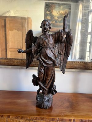 a statue of an angel holding a sword and a shield on a table