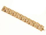 une photo d'un bracelet en or orné de pierres multicolores