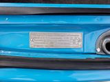 a close up of a blue suitcase with a metal tag on it