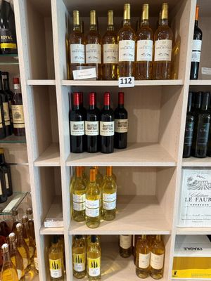 des bouteilles de vin sur une étagère dans un magasin, avec leurs étiquettes de prix
