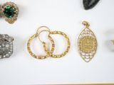 a lot of different rings and brooches on a table