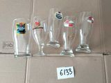 quatre verres à bière vides posés sur une boîte en carton