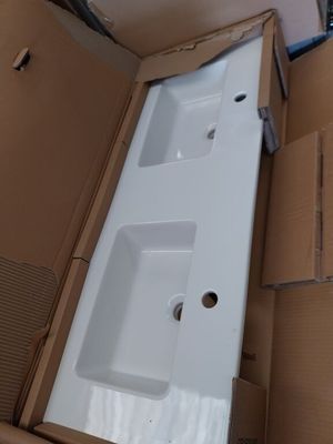un lavabo blanc dans un carton, dans une pièce