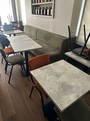 Il y a beaucoup de tables et de chaises dans ce petit restaurant.