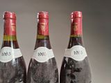 three bottles of wine are lined up on a table