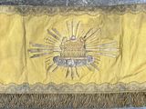 une image représentant un drapeau jaune et noir orné d'un soleil