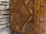 a small chest of drawers with a design on the front
