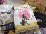 a bag of cat food sitting on top of a pile of other items