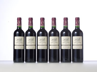 four bottles of wine are lined up on a table
