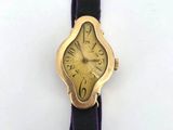 an image of a gold watch with a purple band on a white surface