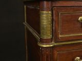 an antique wooden chest of drawers with brass hardware on top of it