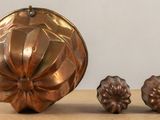 three pieces of metal sitting on a table next to each other
