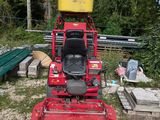 a red lawn mower that is sitting in the dirt