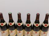 six bottles of wine are lined up in a row on a table