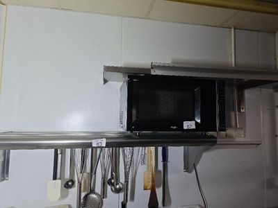 un micro-ondes posé sur une étagère dans la cuisine