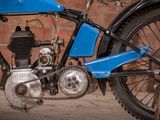 a blue motorcycle that is parked in front of a brick wall