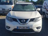 un SUV Nissan blanc garé sur un parking avec d'autres voitures