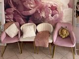 three chairs that are sitting in front of a wall with flowers on it
