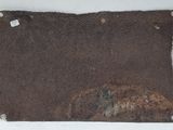 a rusted piece of metal hanging on a wall