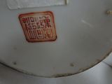 a close up of a white plate with a red design on it