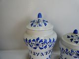 two blue and white vases sitting on a shelf