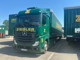 two green trucks parked next to each other in a parking lot