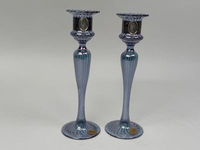 une paire de bougeoirs en verre bleu sur fond blanc