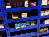 une étagère bleue sur laquelle sont empilées de nombreuses boîtes