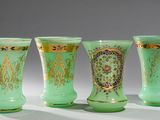 quatre vases verts posés les uns à côté des autres sur une table