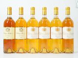 six bouteilles de vin sont alignées sur une surface blanche