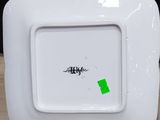 a white square plate with a green sticker on it
