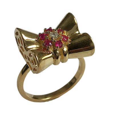 une bague en or ornée d'un nœud rouge et blanc