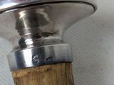 a close up of a wooden handle with a metal knob