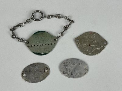 trois types différents d'étiquettes métalliques suspendues à une chaîne sur une surface blanche