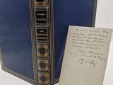 un livre bleu sur lequel il y a des notes, à côté d'une feuille de papier