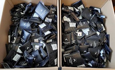 deux boîtes remplies de préservatifs noirs et blancs, posées l'une sur l'autre