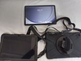 a tablet and a camera on a bed next to each other