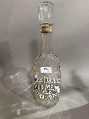 une bouteille en verre sur laquelle est inscrit un message, posée sur une table