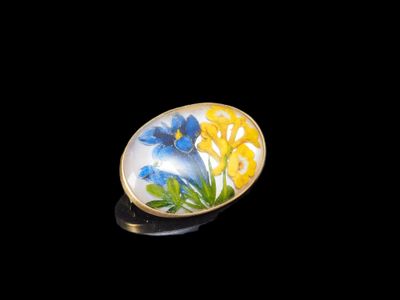 Des fleurs jaunes et bleues sont peintes sur un anneau ovale jaune et bleu