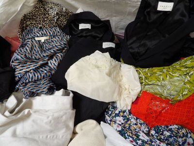 de nombreux vêtements de toutes sortes étalés sur un lit