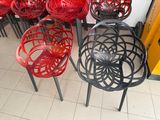 many chairs that are red and black in the store