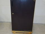 a black refrigerator sitting in the corner of a room