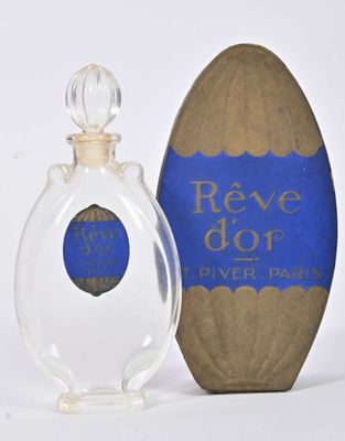 un flacon de parfum posé à côté d'une boîte en carton