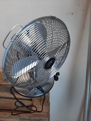 un ventilateur posé sur une table en bois