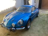 une voiture de sport bleue garée devant une maison