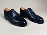 a pair of black leather shoes on a white background